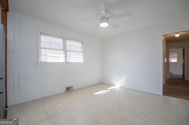 spare room featuring tile patterned floors, a ceiling fan, and visible vents