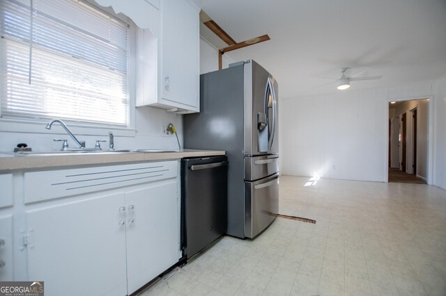 kitchen featuring light floors, light countertops, dishwashing machine, white cabinetry, and a sink