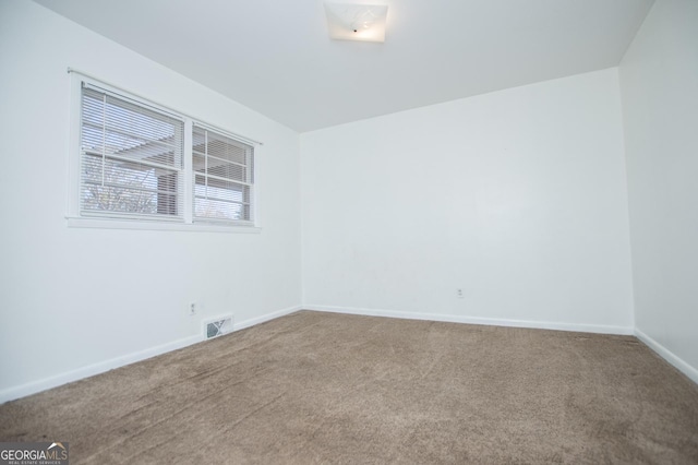 empty room featuring carpet flooring, baseboards, and visible vents