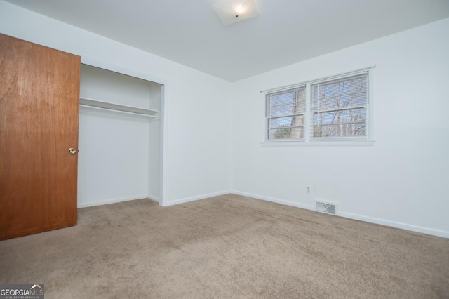 unfurnished bedroom with a closet, visible vents, baseboards, and carpet floors