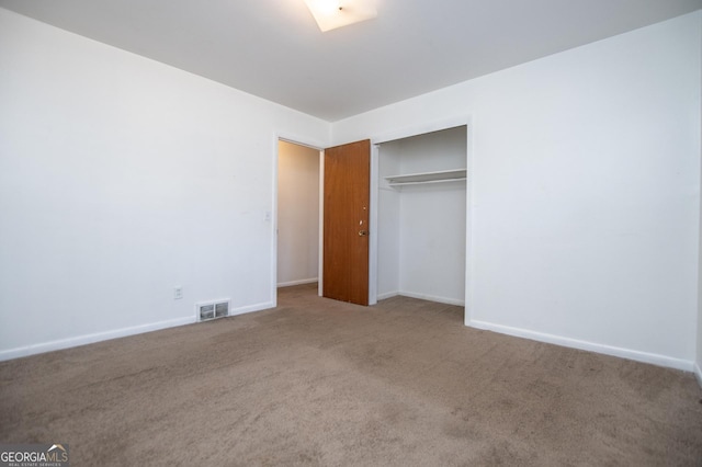 unfurnished bedroom featuring a closet, visible vents, baseboards, and carpet floors