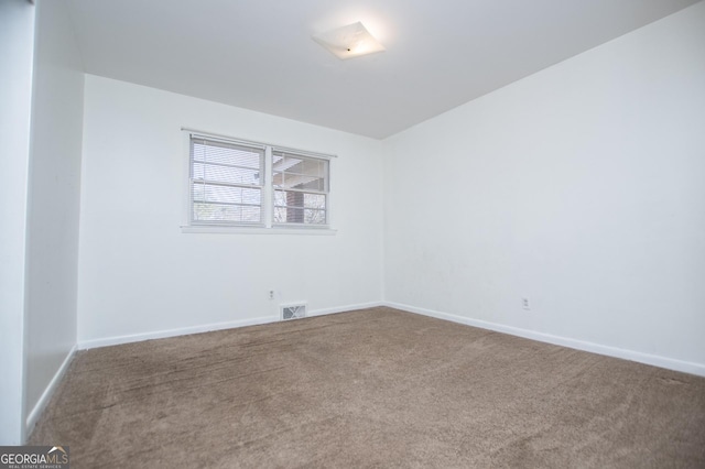 empty room featuring visible vents, baseboards, and carpet