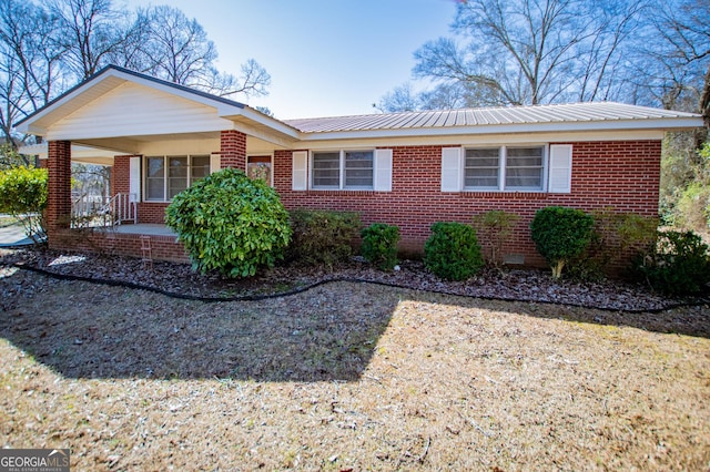 ranch-style home with crawl space, brick siding, and metal roof