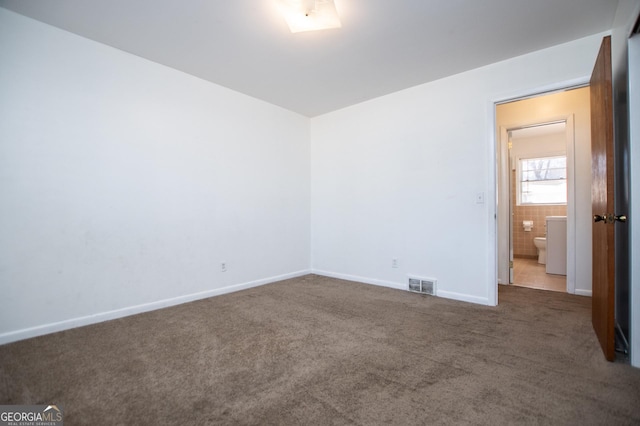 unfurnished bedroom with carpet, visible vents, and baseboards