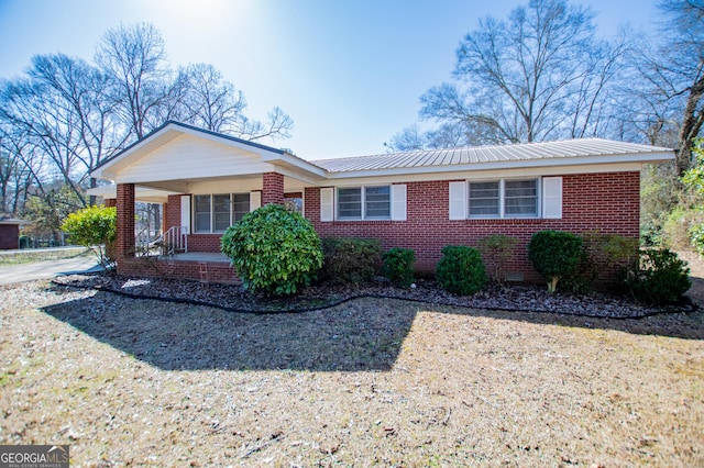 single story home featuring a porch, metal roof, brick siding, and crawl space