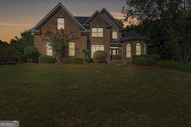 traditional-style house with a yard and brick siding