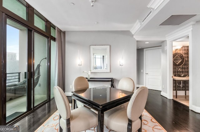 dining area featuring baseboards, wood finished floors, and ornamental molding