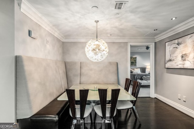 dining area featuring visible vents, wood finished floors, baseboards, and ornamental molding