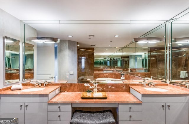 full bath featuring double vanity, a stall shower, and a sink