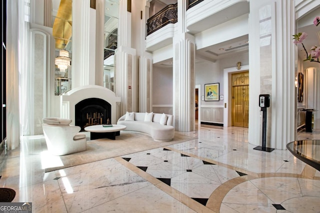 interior space featuring a high ceiling, marble finish floor, and a fireplace