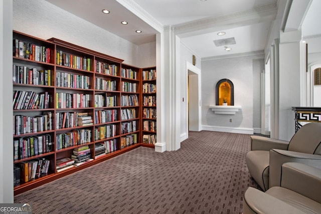 sitting room featuring ornamental molding, bookshelves, recessed lighting, carpet flooring, and baseboards