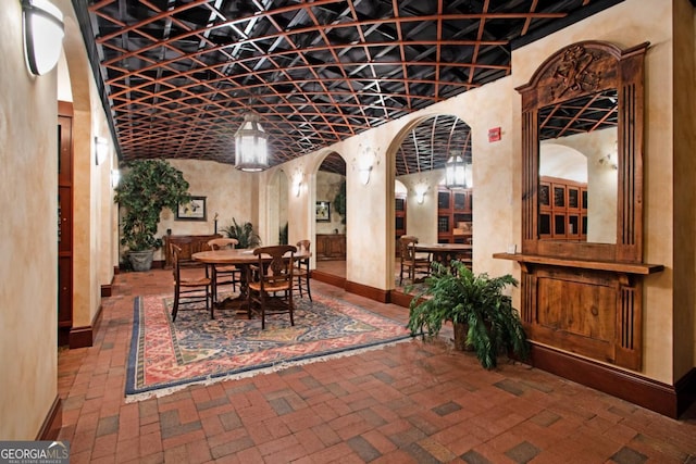 wine area featuring brick floor, baseboards, and arched walkways