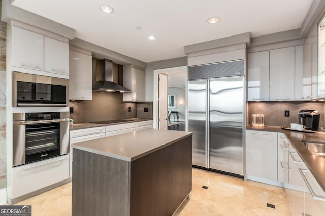 kitchen featuring decorative backsplash, stainless steel appliances, wall chimney exhaust hood, and modern cabinets