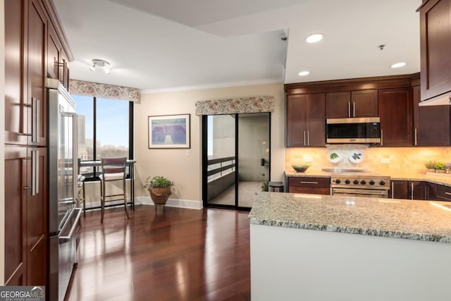 2660 Peachtree Rd NW Unit 14D, Atlanta, GA 30305 - kitchen with high end appliances, dark wood-type flooring, light stone counters, decorative backsplash, and ornamental molding