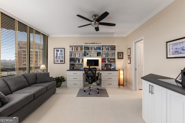 office space featuring light colored carpet, crown molding, and ceiling fan