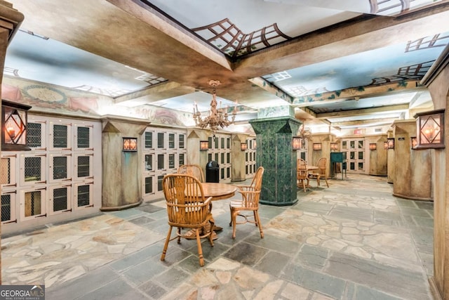 dining area featuring stone tile floors and an inviting chandelier