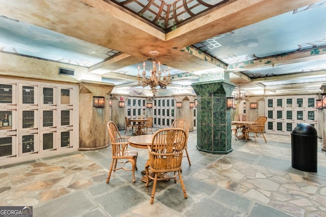 dining room featuring stone tile floors and a chandelier