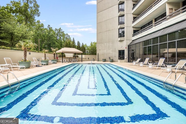 community pool with a patio and fence