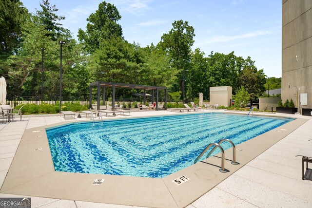 2660 Peachtree Rd NW Unit 14D, Atlanta, GA 30305 - community pool featuring a patio area and view of scattered trees