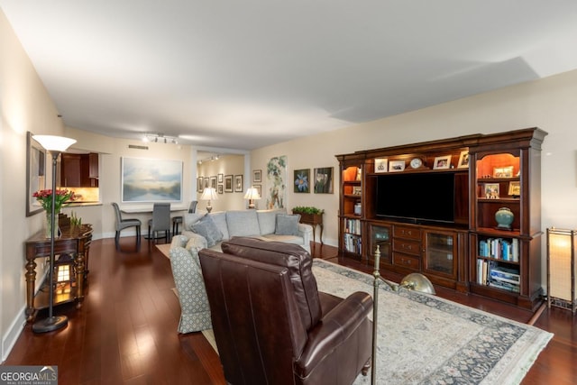 living area with baseboards and dark wood-style flooring