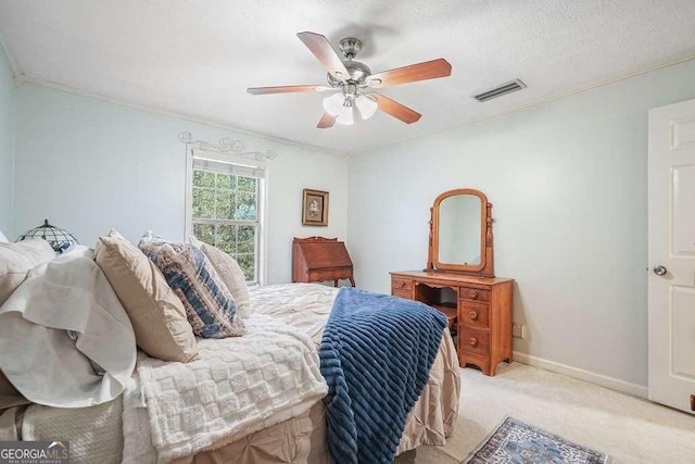 bedroom with visible vents, baseboards, ornamental molding, light carpet, and a ceiling fan