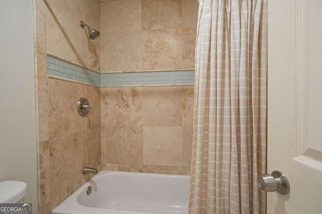 full bath with toilet and shower / bath combo with shower curtain