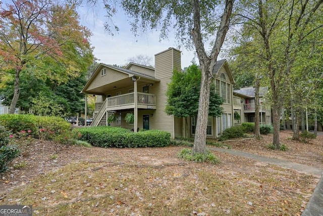 back of property featuring stairs and a chimney