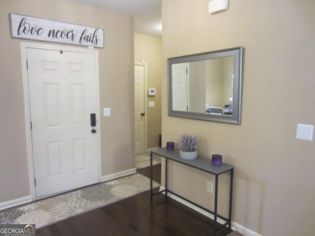 foyer entrance with wood finished floors and baseboards