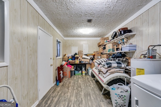 storage area with visible vents, washer / clothes dryer, and water heater