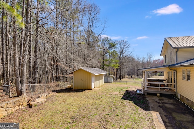 view of yard with a storage shed, an outdoor structure, and fence