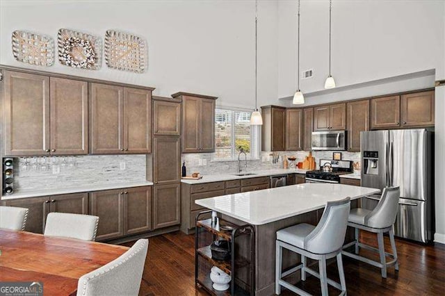 kitchen with dark wood finished floors, visible vents, appliances with stainless steel finishes, and a sink