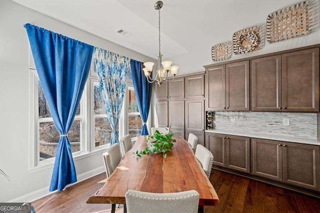 dining space with visible vents, baseboards, an inviting chandelier, and dark wood-style flooring