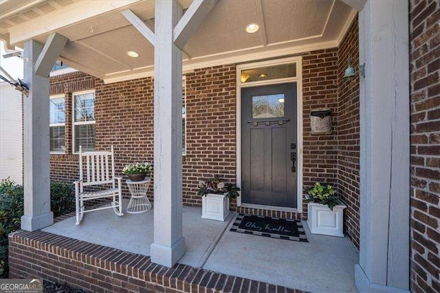 entrance to property featuring brick siding and a porch