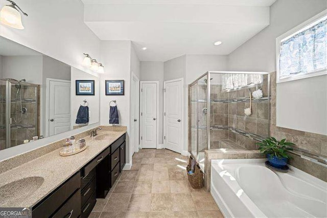 full bath with a sink, a garden tub, a stall shower, and double vanity