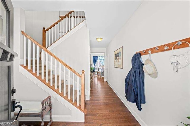 interior space with stairway, baseboards, and wood finished floors