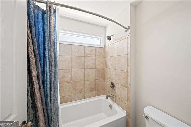 bathroom with toilet and shower / bathtub combination with curtain