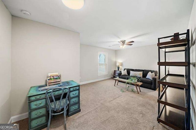 living area featuring carpet flooring, ceiling fan, and baseboards