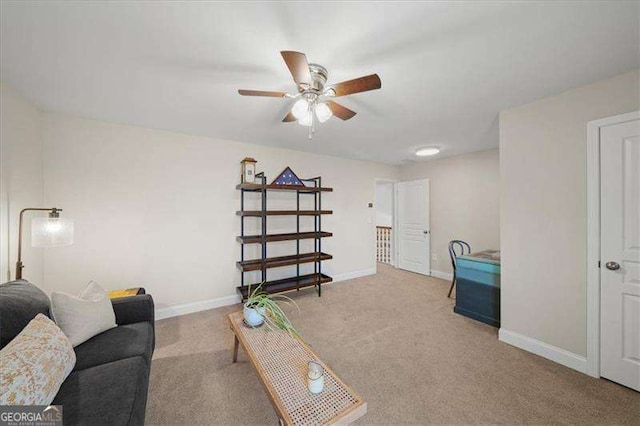 carpeted living area featuring a ceiling fan and baseboards