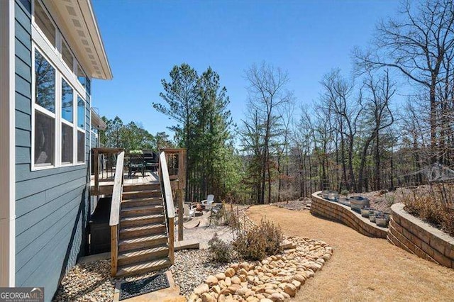 view of yard featuring a wooden deck and stairs