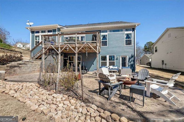 rear view of house with a patio area, stairway, a fire pit, and a deck