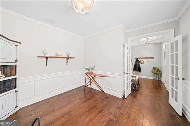 interior space featuring french doors, wainscoting, crown molding, and hardwood / wood-style flooring