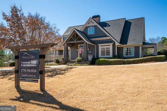 view of front of house with a chimney and a front lawn