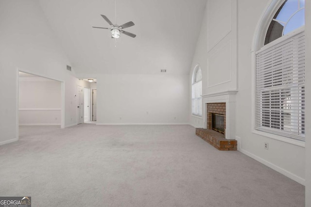 unfurnished living room featuring ceiling fan, a brick fireplace, light carpet, and high vaulted ceiling