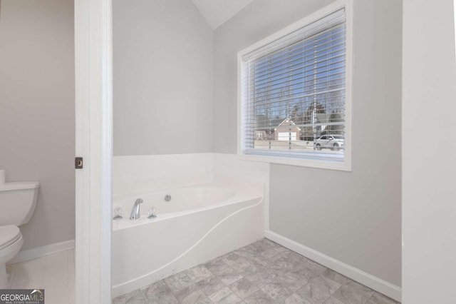 full bath featuring baseboards, toilet, and a garden tub