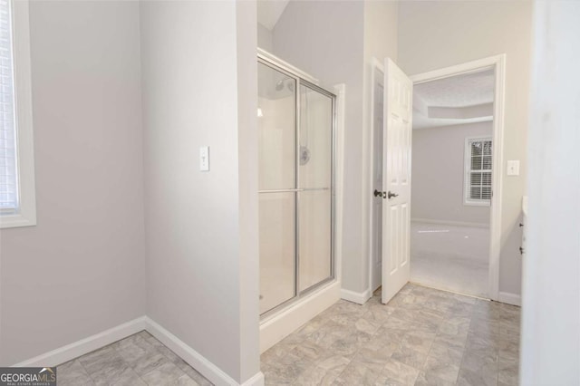 bathroom featuring baseboards and a stall shower