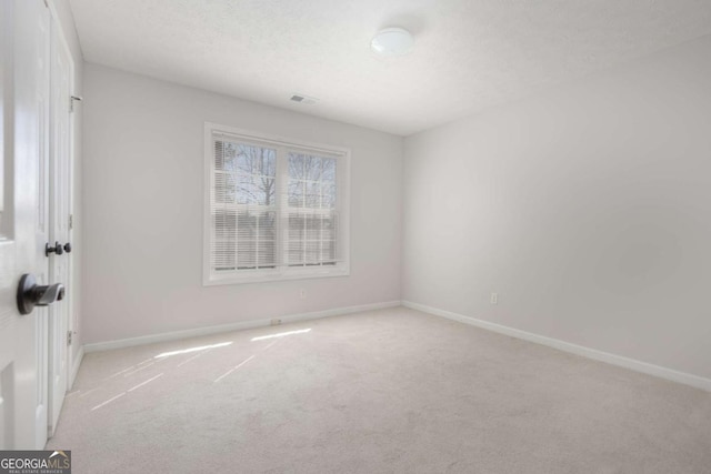 empty room with visible vents, baseboards, carpet, and a textured ceiling