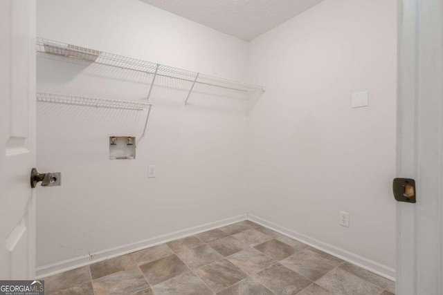 laundry room with electric dryer hookup, washer hookup, a textured ceiling, baseboards, and laundry area