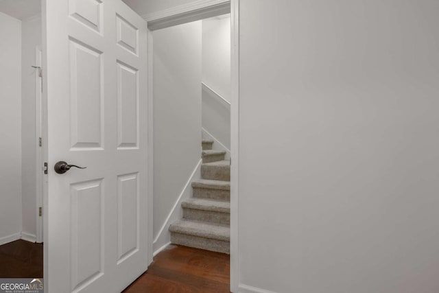 staircase featuring baseboards and wood finished floors