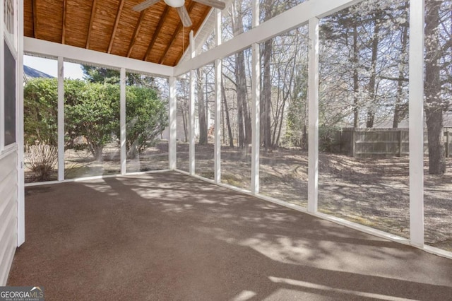 unfurnished sunroom featuring ceiling fan, wooden ceiling, and vaulted ceiling