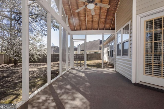 unfurnished sunroom with a ceiling fan, lofted ceiling, and wood ceiling